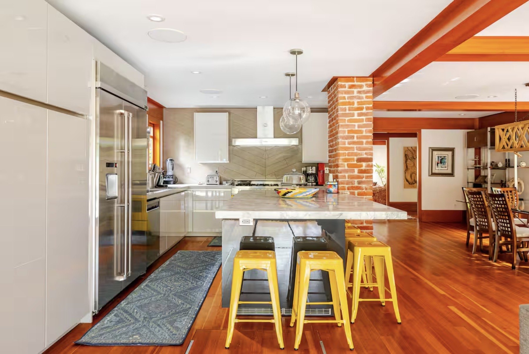 Kitchen with yellow stools and brick column
